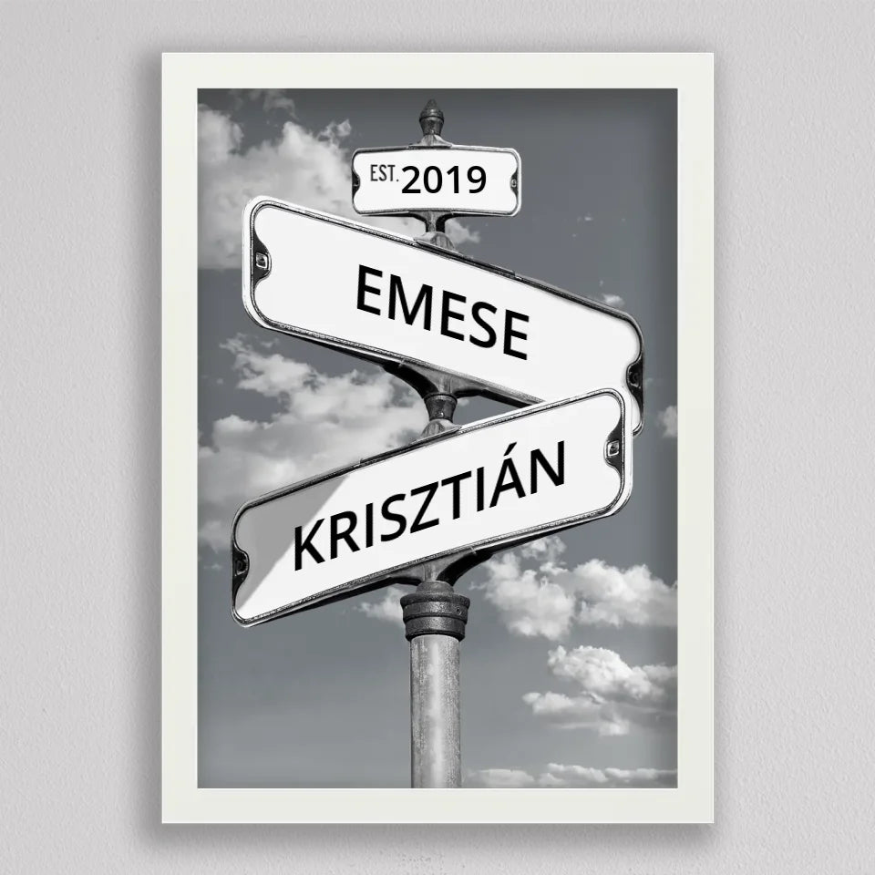 Szerelmes utcanévtábla kép fehér keretben, fekete-fehér felhős háttér előtt két egymást keresztező tábla