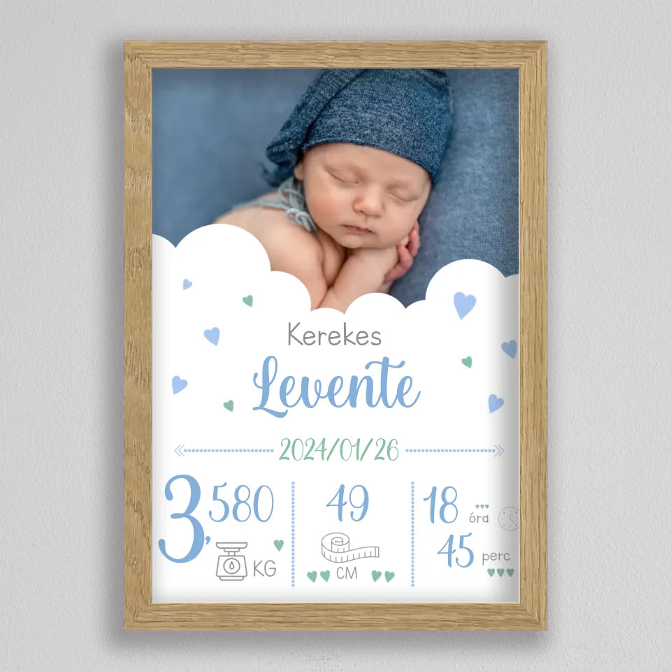 Születési adatos plakát kisfiúnak tölgyfa hatású keretben, kék kézírásos név, felhők és kék, zöld szívecskék
